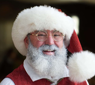 A person wearing a red and white Santa hat is partially visible against a blurred indoor background.

Description generated by AI